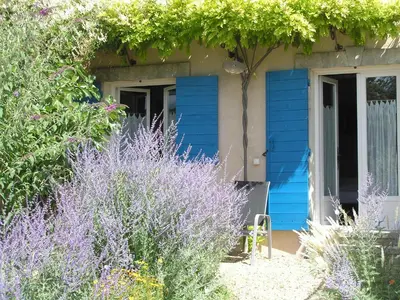 a blue house with some purple bushes and flowers at Clos des Lavandes - Chambres et Suites de charme climatisées-Luberon in Lacoste