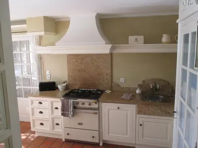 a white kitchen with a stove and a sink at L'Hymette in Blauvac