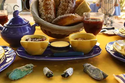 a table with a plate of food and a bowl of bread at Mas la Cigaliere in Venasque