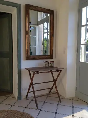 a wooden table in a room with a mirror at La Calade in Lourmarin