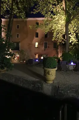a planter in front of a building at night at Hotel du Poète in Fontaine-de-Vaucluse