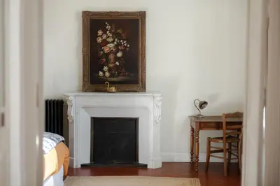 a room with a fireplace with a painting on the wall at La Madone in Apt