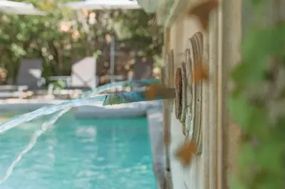 a pool with a water hose hooked up to a wall at La Madone in Apt
