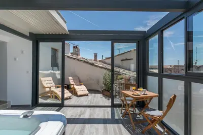 a room with a balcony with a table and chairs at Nuit Etoilée in LʼIsle-sur-la-Sorgue