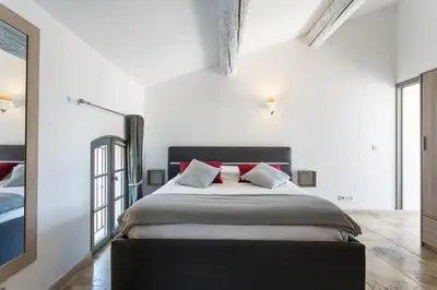 a bedroom with a large bed with red pillows at Nuit Etoilée in LʼIsle-sur-la-Sorgue
