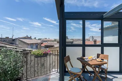 a patio with a table and chairs on a balcony at Nuit Etoilée in LʼIsle-sur-la-Sorgue