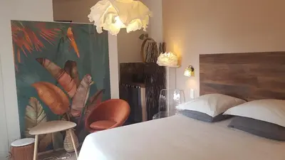 a bedroom with a bed and a painting of feathers at La Maison de Charlie in Vaugines