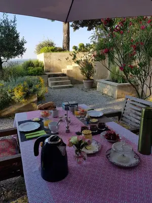 a table with a purple table cloth with food on it at La Maison de Charlie in Vaugines
