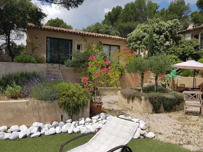 a yard with two white chairs and a house at La Maison de Charlie in Vaugines