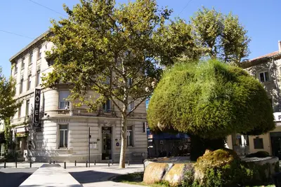 a building with a tree in front of it at Grand Hôtel De La Poste in Salon-de-Provence