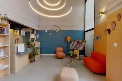 a waiting room with orange furniture and a blue wall at City Résidence Aix-en-Provence in Aix-en-Provence