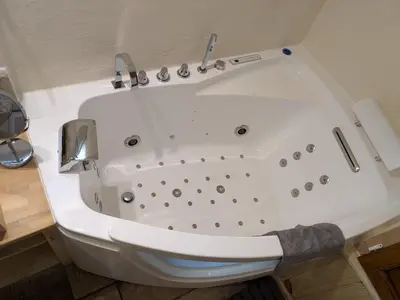 a large white bath tub in a bathroom at Les Rapieres Mireio in Gordes
