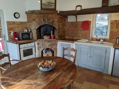 a kitchen with a wooden table with a bowl of fruit at Les Rapieres Mireio in Gordes