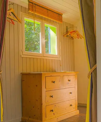 a room with a wooden dresser and a window at Le Cabanon in Le Thor