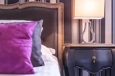 a lamp on a night stand next to a bed at Hôtel des Augustins in Aix-en-Provence