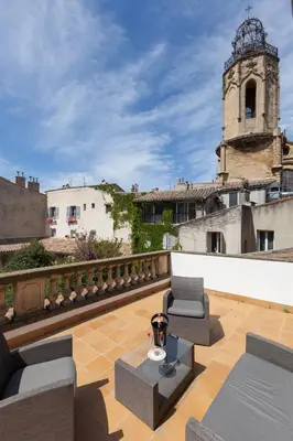 a patio with chairs and a table and a building at Hôtel des Augustins in Aix-en-Provence