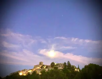 a building on top of a hill at night at Le 47 - Rentals in South of France in Beaumont-de-Pertuis