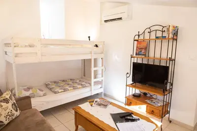 a living room with a bunk bed and a tv at Appartement spacieux Rochereau in LʼIsle-sur-la-Sorgue
