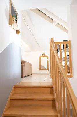 a staircase in a house with a mirror at Appartement spacieux Rochereau in LʼIsle-sur-la-Sorgue