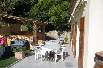 a patio with a table and chairs on the side of a house at le clos des sources in Saint-Chamas