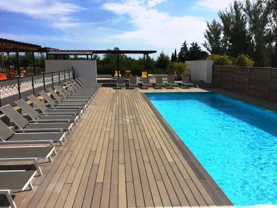 a swimming pool with chaise lounges and chairs on a patio at Les Terrasses D'Aix - Studio avec Grande Terrasse privée in Aix-en-Provence