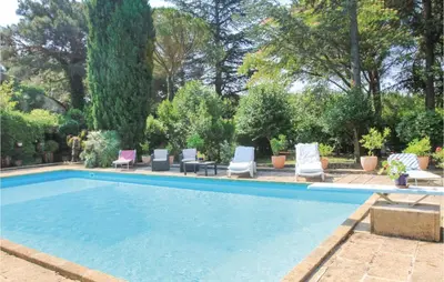 a swimming pool with chaises and lounge chairs in a yard at Amazing Home In Lançon De Provence in Lançon-Provence