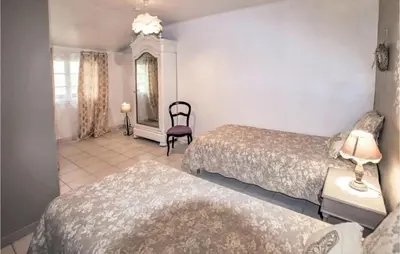 a hotel room with two beds and a chair at Amazing Home In Lançon De Provence in Lançon-Provence