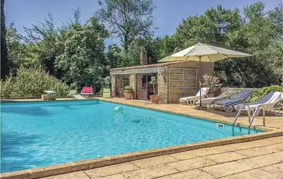 a swimming pool with an umbrella and two lawn chairs and an umbrella at Amazing Home In Lançon De Provence in Lançon-Provence