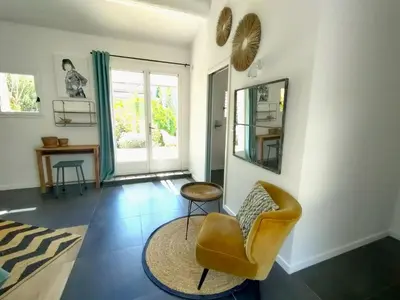 a living room with a chair and a mirror at Villa Cabrida in Cabrières-dʼAvignon