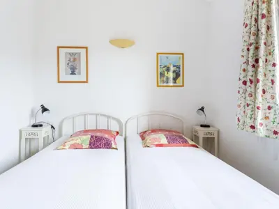 two twin beds in a bedroom with two tables at Holiday Home Les Vignes by Interhome in Ménerbes