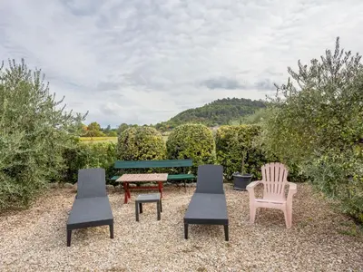a group of chairs and a bench in a yard at Holiday Home Les Vignes by Interhome in Ménerbes