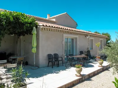 a patio with a table and chairs and an umbrella at Holiday Home Les Vignes by Interhome in Ménerbes
