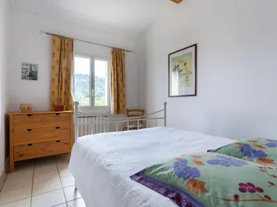 a bedroom with a bed and a dresser and a window at Holiday Home Les Vignes by Interhome in Ménerbes