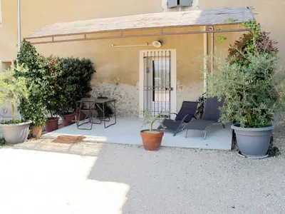 a patio with a table and chairs and plants at Holiday Home L'Olivier by Interhome in Ménerbes