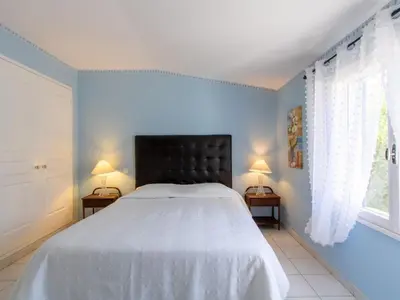 a bedroom with a bed with a black headboard and two lamps at Holiday Home Les Amandiers by Interhome in Mazan