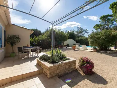 a patio with a table and chairs under a pergola at Holiday Home Les Amandiers by Interhome in Mazan