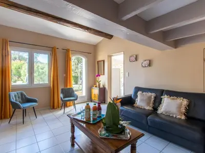 a living room with a blue couch and a table at Holiday Home Les Amandiers by Interhome in Mazan
