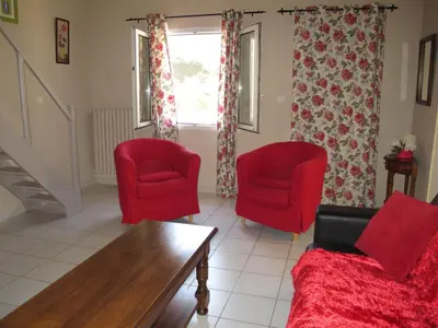 a living room with two red chairs and a table at Holiday Home Les Amandiers by Interhome in Mazan