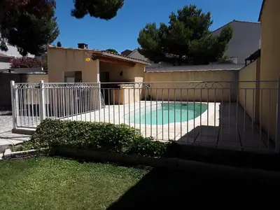 a fence around a swimming pool in a house at Maison les pins in Vedène