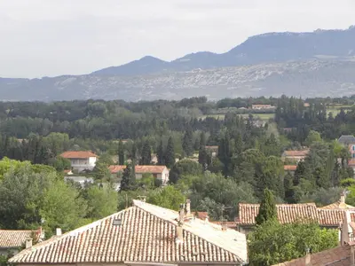 a view of a town with trees and mountains at Ogooué appartement entier Lumineux 94m2 in Carpentras