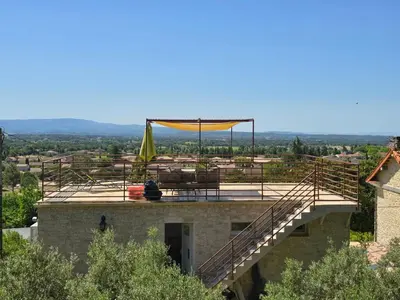 a building with a patio and a yellow umbrella on top at Le Mas de la Tortue (Toit Terrasse) in Caromb
