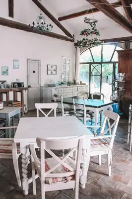 a dining room with white tables and chairs at La Bastide des Songes - Demeure d'hôtes in Robion en Luberon