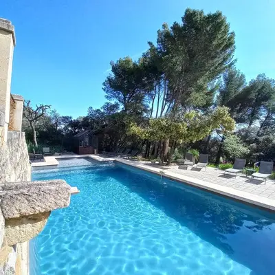 a swimming pool with blue water in a yard at Le Bastion des Papes in Châteauneuf-de-Gadagne