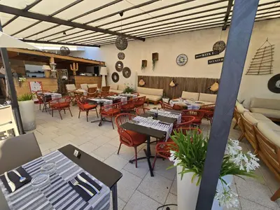 a restaurant with tables and chairs in a room at Les Loges du Luberon in Coustellet
