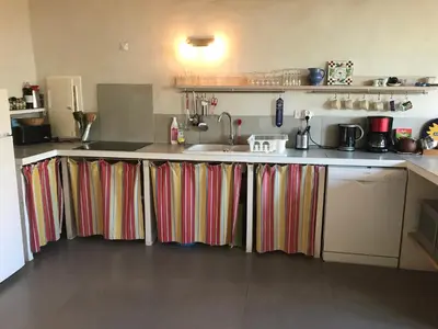 a kitchen with colorful curtains on the counters at Gite Les Enfantines in Bédoin