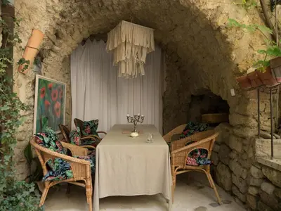 a kitchen with a table with a vase on top of it at La Cordière in Lourmarin