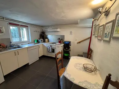 a kitchen with white cabinets and a table and a table and a table at Chez Zabou in Carpentras