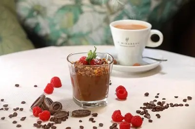 a cup of coffee and strawberries on a table at Negrecoste Hôtel & Spa in Aix-en-Provence