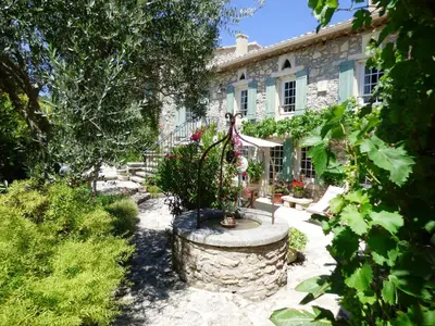 a garden in front of a stone house at Semi-detached provencal farm with swimming pool in Orgon