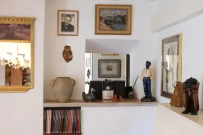 a living room with a shelf with a mirror and artifacts at Semi-detached provencal farm with swimming pool in Orgon